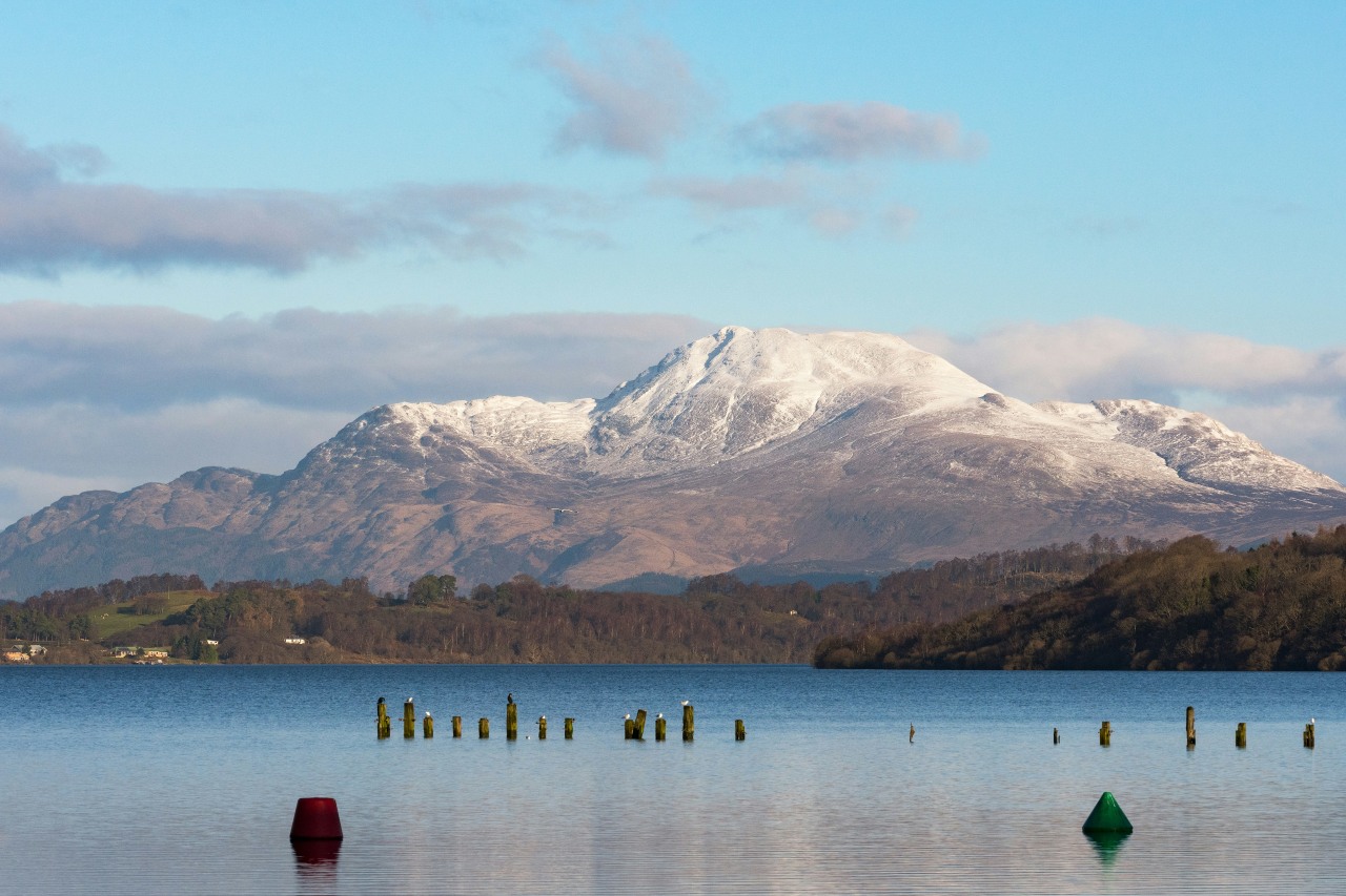 Snow-capped Ben Lomond looms over the still waters of Loch Lomond (Gary Ellis/Unsplash)