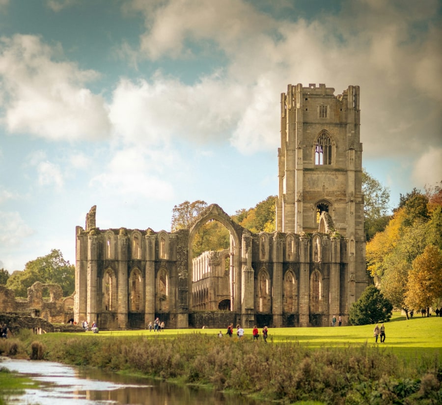 The dramatic ruins of Fountains Abbey set by the River Skell (Ben Wicks/Unsplash)