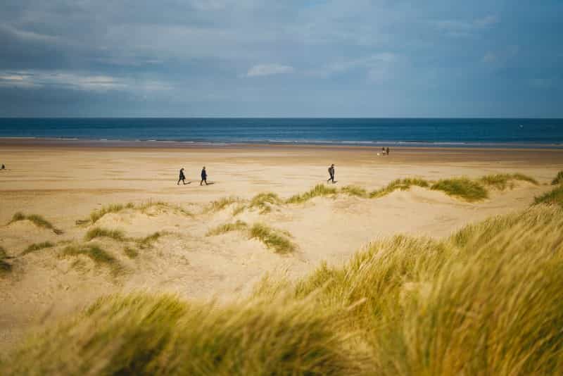 Take a walk along the sandy beach at Wells-next-the-sea (Phil Hearing on Unsplash)